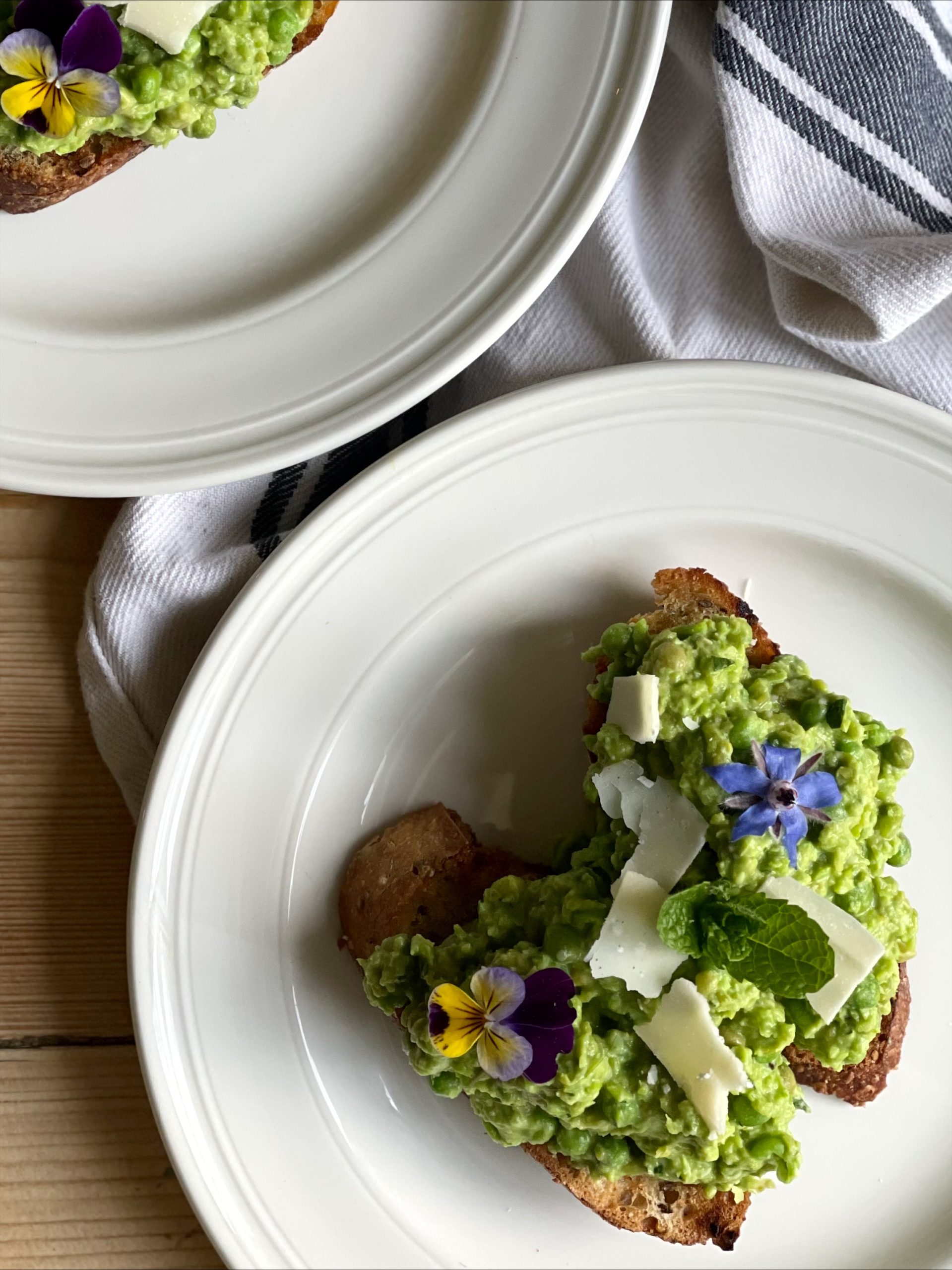 Smashed peas on garlicky toast with edible flowers