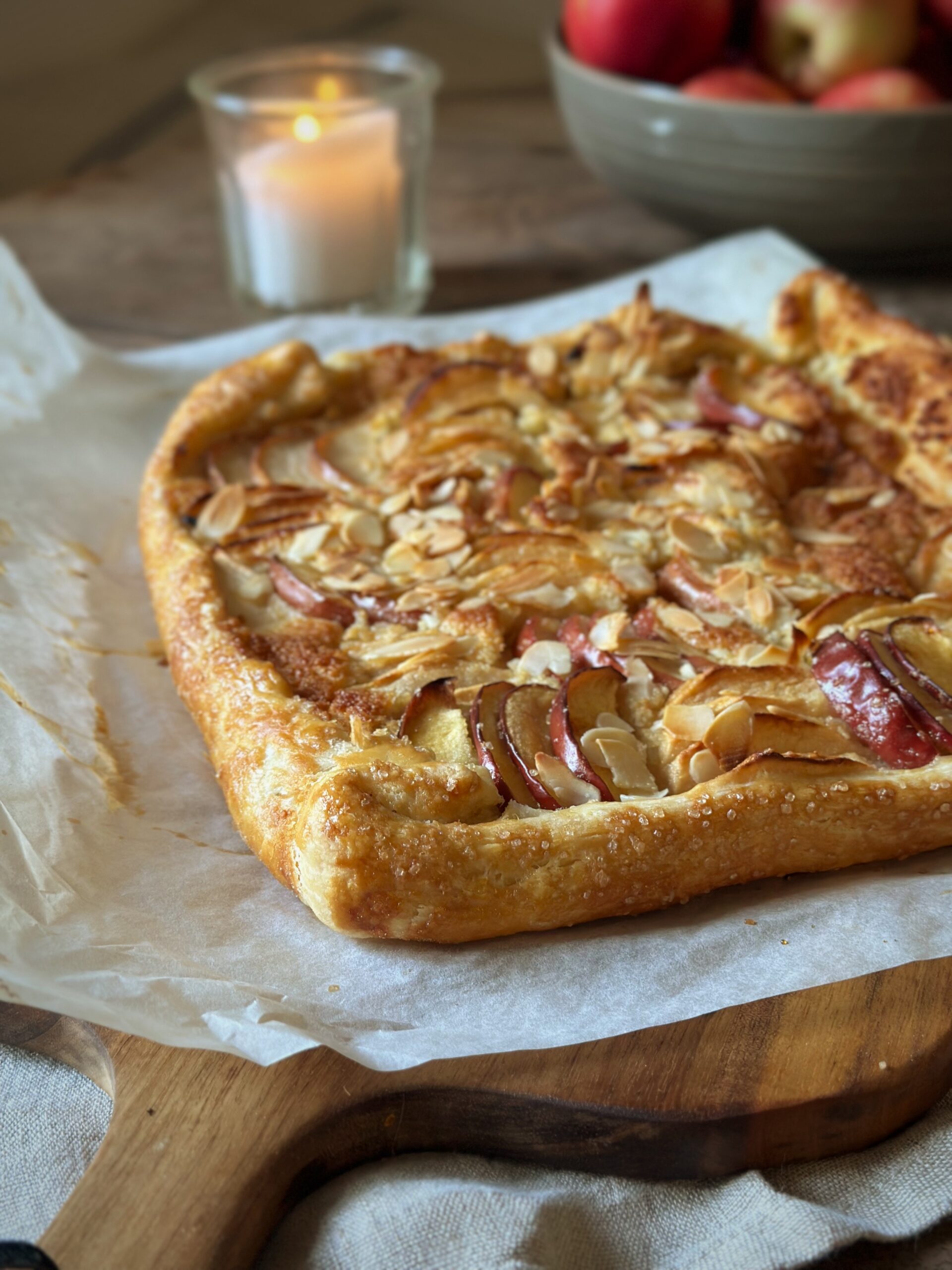 A rustic apple and almond galette, filled with an almondy frangipane and piled with sliced apples. The pastry is folded over on the edges to hold in the tart filling.